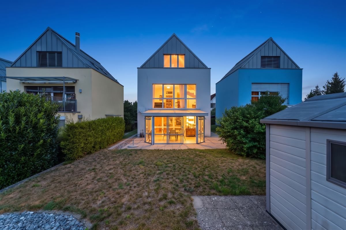 House exterior after twilight conversion, dusk sky with glowing windows